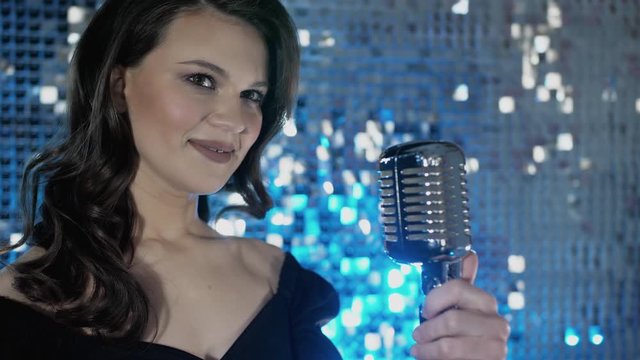 Excitement of portrait confident beautiful woman singer holds microfon on event concert. Young lively female fashion person entertainer close eyes, smiling emotion. Occupation lifestyle in club studio