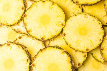 Pineapple juicy yellow slices background. Top view.
