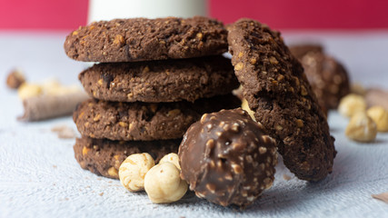 Chocolate cookies for breakfast with mint and hazelnut and a glass of milk on a gray table