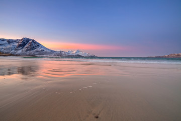 Amazing sunrise with amazing magenta color over sand beach. Tromso, Norway . Polar night. long shutter speed