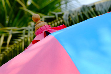 Closeup top of umbrella and colorful pink and blue color fabric panel