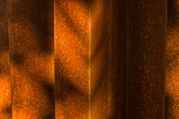 Abstrakte Detailaufnahmen einer verrosteten Stahlkonstruktion mit selektivem Fokus bei Seitenlicht, abwechselnd helle Bereichen und Schattenbereiche