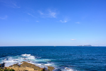 Fototapeta na wymiar 冬の岩屋海岸に広がる青空と波しぶき【福岡県】