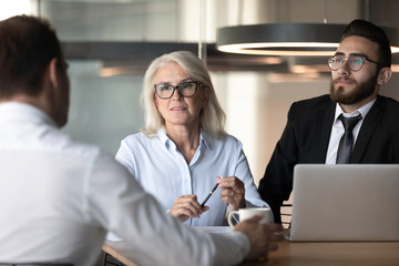 Diverse company representatives negotiating with corporate client at group meeting
