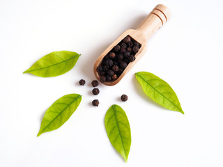 Top view of cereal dried food whole grains with black pepper in wooden scoop and fresh green leaves...