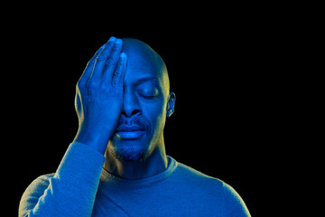 Colorful portrait of a black man. One eye covered with the hand and the other eye closed. Vibrant...