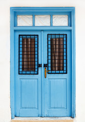 Fototapeta na wymiar Beautiful old blue door. Fragment of the facade of the house, Cyprus, Europe.