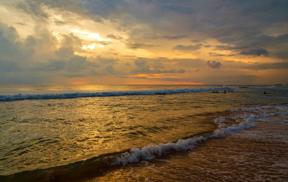 Reflection of vivid sunset sky over sea and beach.Colorful sunrise with Clouds over ocean. Pink and yellow sunset over the ocean with clouds, Sri Lanka, Asia, Ceylon