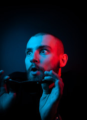 Studio portrait of a charismatic guy in neon style. Stock photo of a bearded guy surprised by...