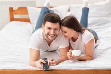 Joyful Boyfriend And Girlfriend Watching TV Together Lying In Bed