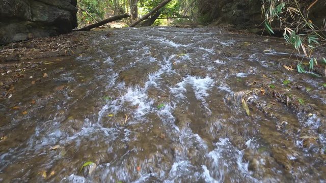 stream clear water or shallow pow for nature holiday relax and summer vacation travel with green tree trekking and stone in forest at nang khruan waterfall 1st floor in lam khong ngu national park 4K