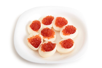 Red caviar on boiled chicken egg. Isolated object on a white background