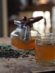 Herbal medicine.The concept of the benefits of green herbal tea for health. A teapot and cups on a wooden table with gulls, leaflets of green tea and medicinal
