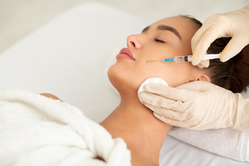 Woman receiving anti wrinkle injection in beauty clinic