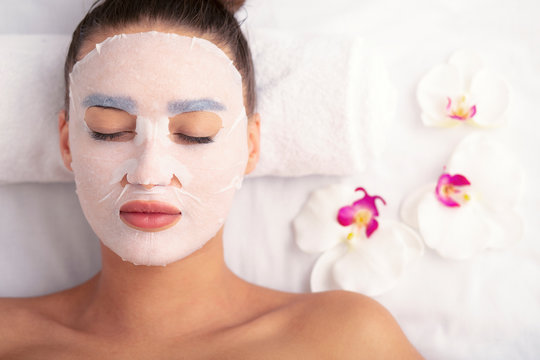 Woman with cotton face mask in beauty salon