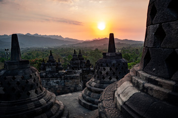 sunset at borobudur with stupas in indonesia - obrazy, fototapety, plakaty