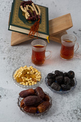food Ramadan Sweets mixed of dried fruits and nuts Glass Tea with  rosary and the Quran on the table,  Concept: month fasting culture Muslim and prayer for god, Ramadan food symbolic eastern Arabian