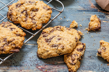 Chocolate cookies, on rustic wood next to cocoa in different forms