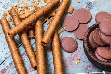 Chocolate cookies, on rustic wood next to cocoa in different forms