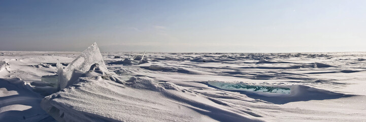 Transparent ice hummock in the snow on Lake Baikal in Siberia, Russia. Wide panorama background