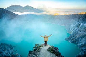 woman standing on the edge of the lake in vulcano ijen