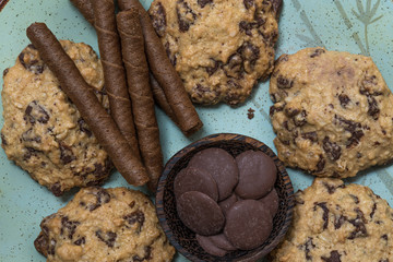 Chocolate cookies, on rustic wood next to cocoa in different forms
