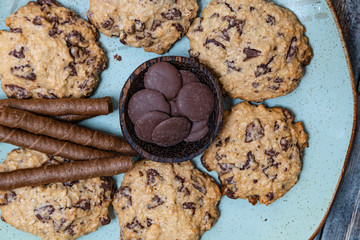 Chocolate cookies, on rustic wood next to cocoa in different forms