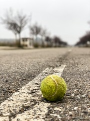 pelota dde tenis en una carretera de asfalto abandonada 