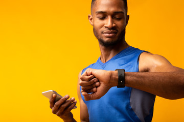 Headshot of afro guy looking at his wrist watch