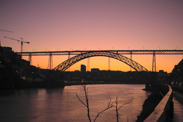 Fototapeta na wymiar Purple and Orange sunset Dom luis Bridge in Porto Portugal