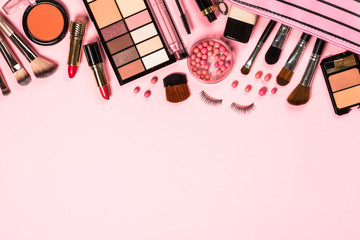 Makeup professional cosmetics on pink background.