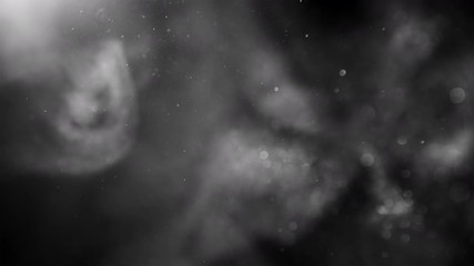 Glitter flying in wind. Underwater particles shining in bright spot light, shot with depth of field. Black and white abstract background. Can be graded in any color by tint effect