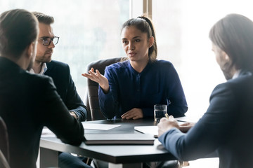 Attractive mentor businesswoman conducts coaching in boardroom at company meeting.