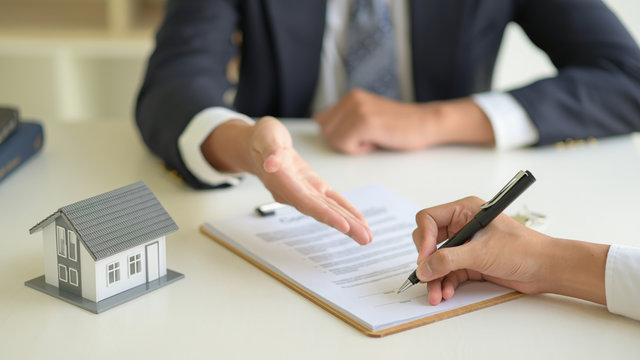 Signing a home purchase contract between the house broker and the client.