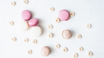 Food background. Biscuit composition. Pink beige macaroons cereal rings on white surface.