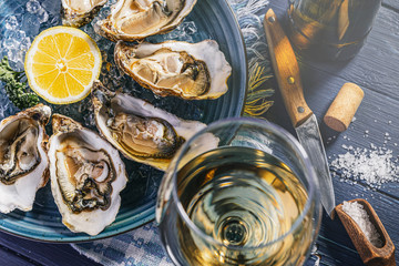 Fresh oysters with lemon ice and white wine. - obrazy, fototapety, plakaty