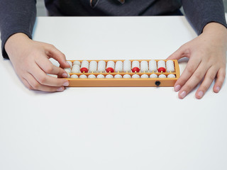 Classes in mental arithmetic, hands and abacus soroban on white background. closeup