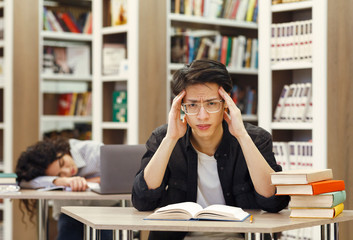 Tired students studying in the university library