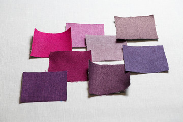 square pieces of multi-colored fabric laid out on a gray background