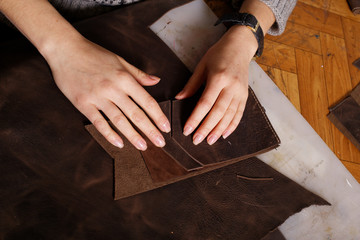  In workroom girl&#39;s hands makes purse.