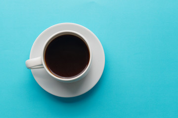 White coffee cup on blue kitchen table. Top view with copyspace for your text.