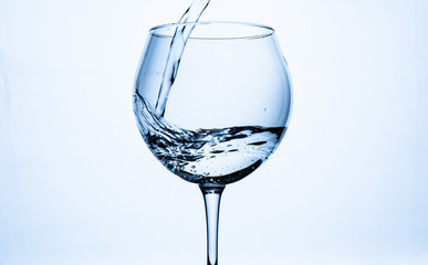 water with splashes poured into the glass on a white background.