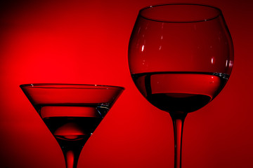 two glasses of water in red light.