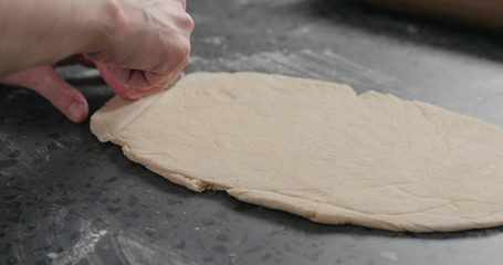man cutting flat dough with knife