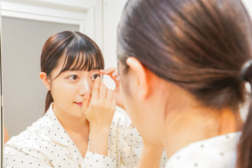 コンタクトレンズを装着する若い女性