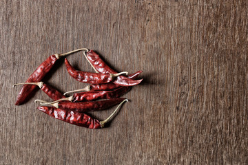 Bunch of dried red chilli peppers on a wooden board
