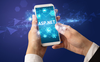 Female hand holding smartphone with ASP.NET inscription, modern technology concept