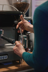 Hand with a pitcher. Whipping milk. Barista