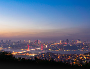 View from Camlica hill to 15 July Martyrs bridge with Besiktas scyscrapers in the background. Romantic  Istanbul during sunset. Turkey. Blank space image.