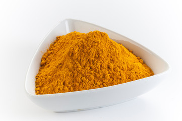 yellow turmeric/haldi powder in white bowl